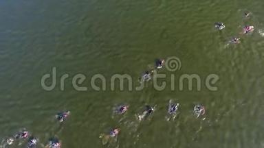 在水上竞赛中，铁人三项选手从上到下穿越深绿色的河流